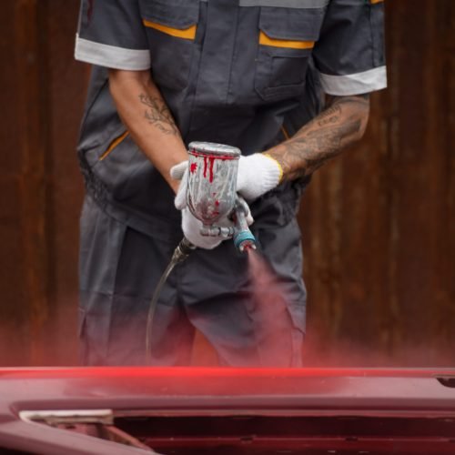 97009 Auto body technician using power tool on vehicle